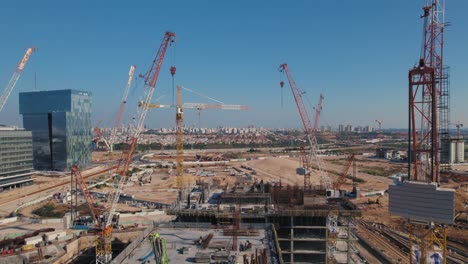 empuje de drones entre 11 grúas en un edificio de oficinas en construcción - día soleado sin nubes