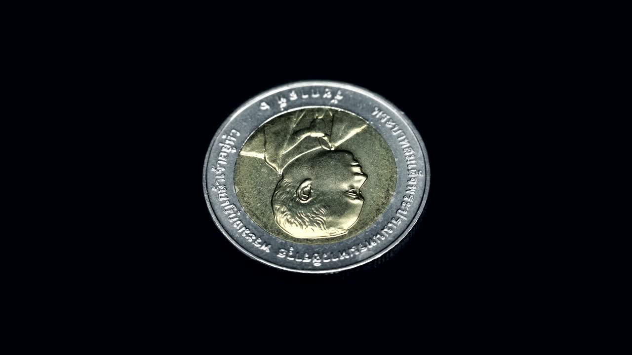 moneda conmemorativa de tailandia (baht) gira sobre un fondo negro. macro. primer plano