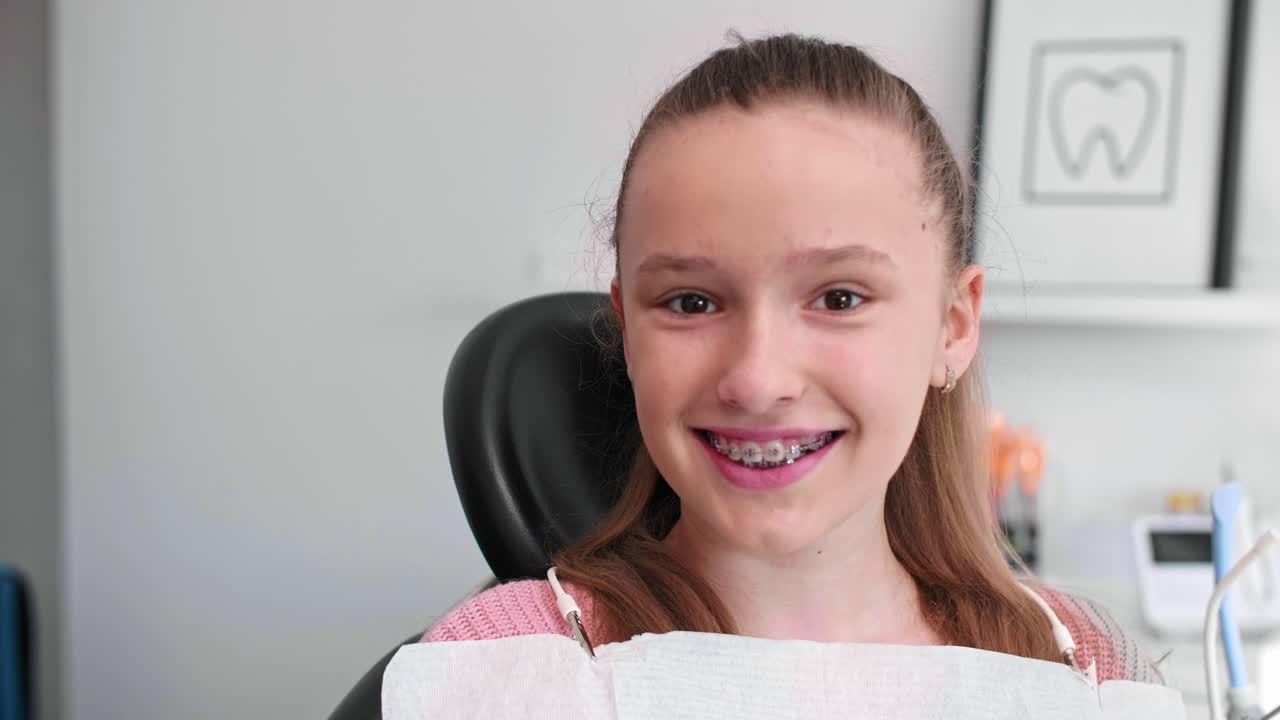 Portrait of smiling teenage girl with braces in dentist's office