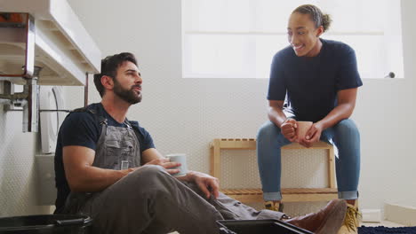 male plumber with female apprentice taking a break from fixing leaking sink in home bathroom