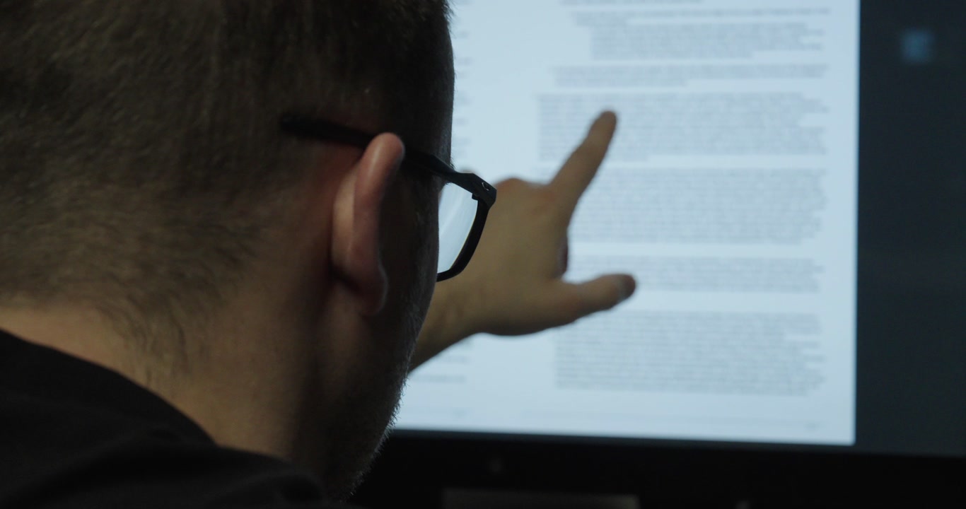 a man secretly photographing confidential documents in an office. Concept of data theft, corporate espionage and security risk.