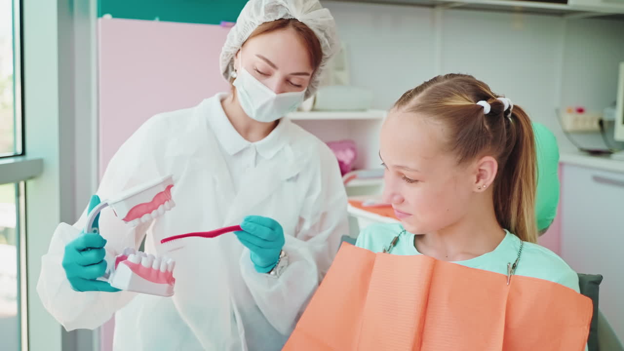 Dentist teaching a child about teeth brushing