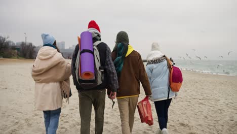 friends walking on a beach in winter