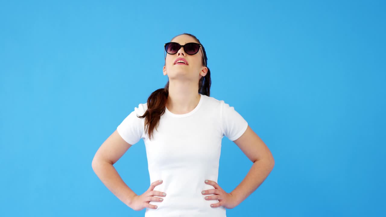 선글라스를 입은 아름다운 여성이 쳐다보고 있습니다.