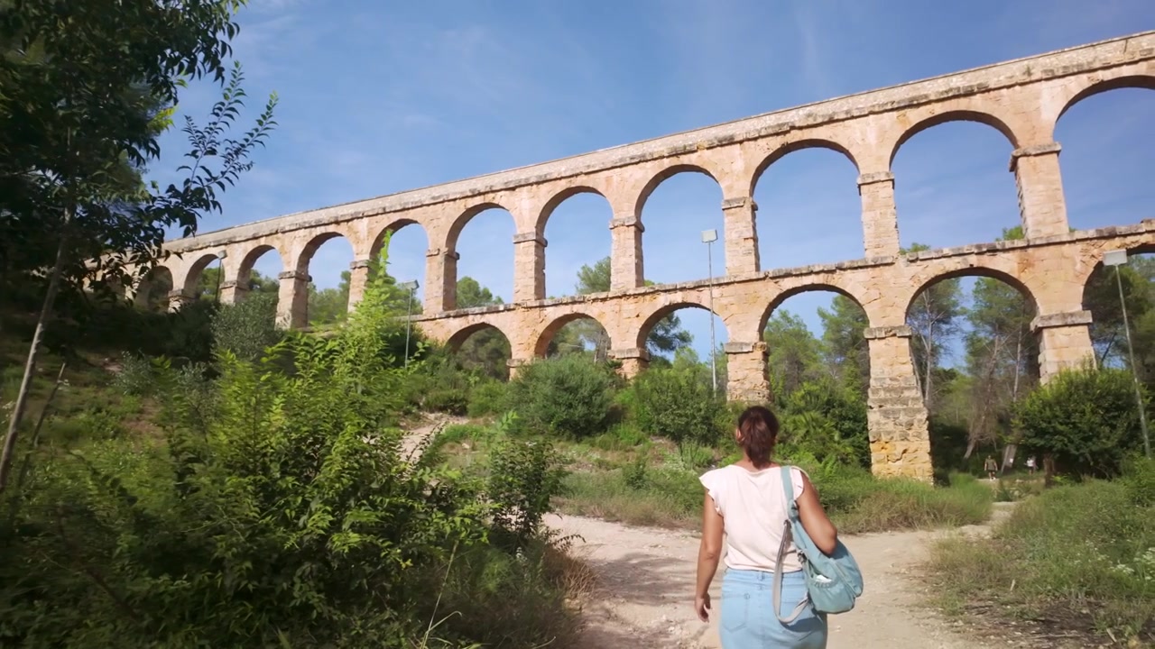 Donna che cammina verso l'acquedotto romano di Tarragona
