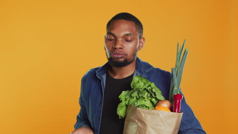 un tipo vegano afroamericano tomando un bocado de una manzana verde natural madura