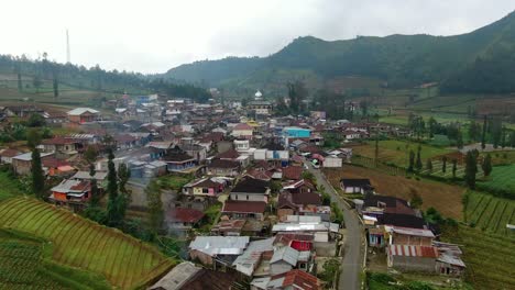 aerial view of traditional village surrounded by hills on java island, indonesia