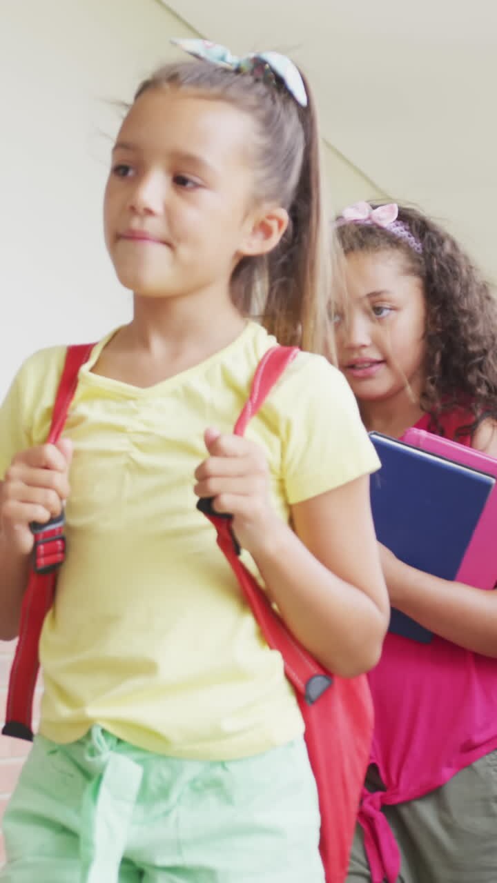 Video de niñas diversas felices caminando por el pasillo de la escuela