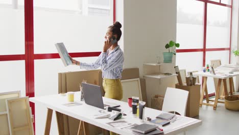 Video-De-Una-Feliz-Diseñadora-Birracial-Usando-Un-Teléfono-Inteligente-En-El-Estudio