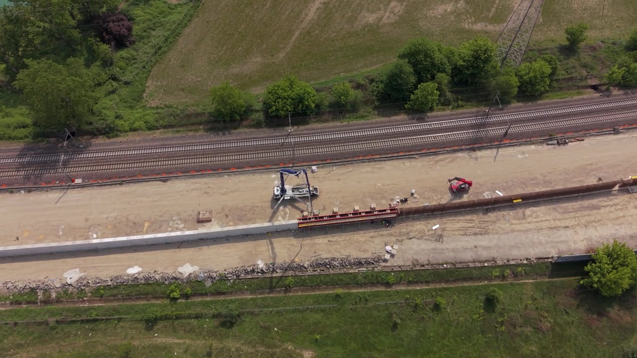 Riprese aeree dello sviluppo dell'infrastruttura ferroviaria sul corridoio Milano-Pavia nell'Italia settentrionale. I lavori di costruzione mostrano l'espansione della moderna connettività dei trasporti.