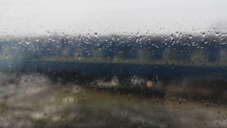 suburban train movement through wet glass from rain