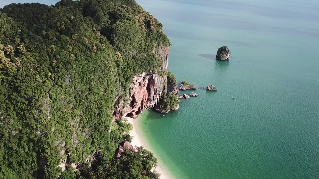Scogliera calcarea con foresta pluviale sopra la spiaggia di sabbia bianca di Railay.