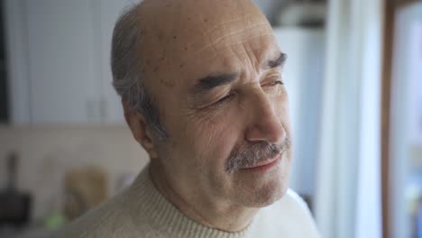 Sad-retired-old-man-at-home-alone-thoughtfully-looking-out-the-window.