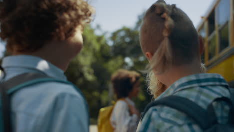 elementary age boys talking joking at school bus. teen friends communicating.