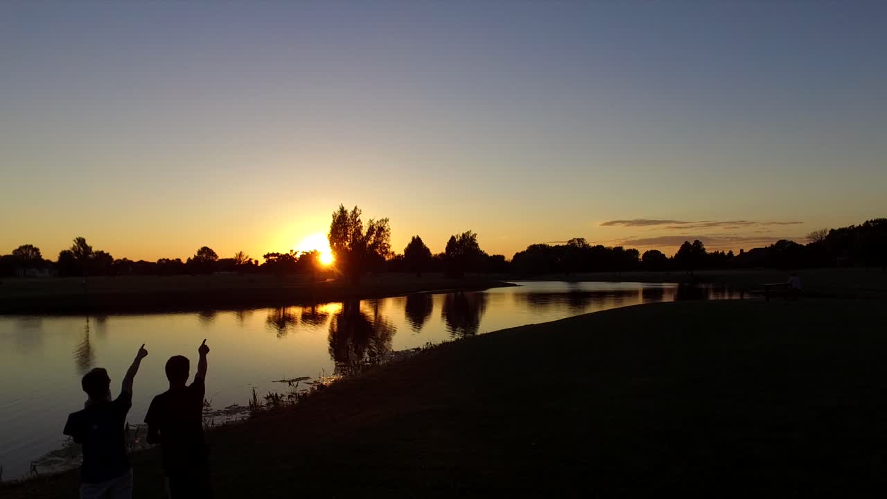 gente señalando a la hermosa puesta de sol
