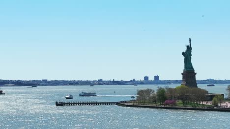 aerial panorama view showing cruising boats with tourist beside statue of liberty in new york