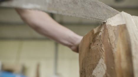 carpenter cutting wood with handsaw in workshop 1