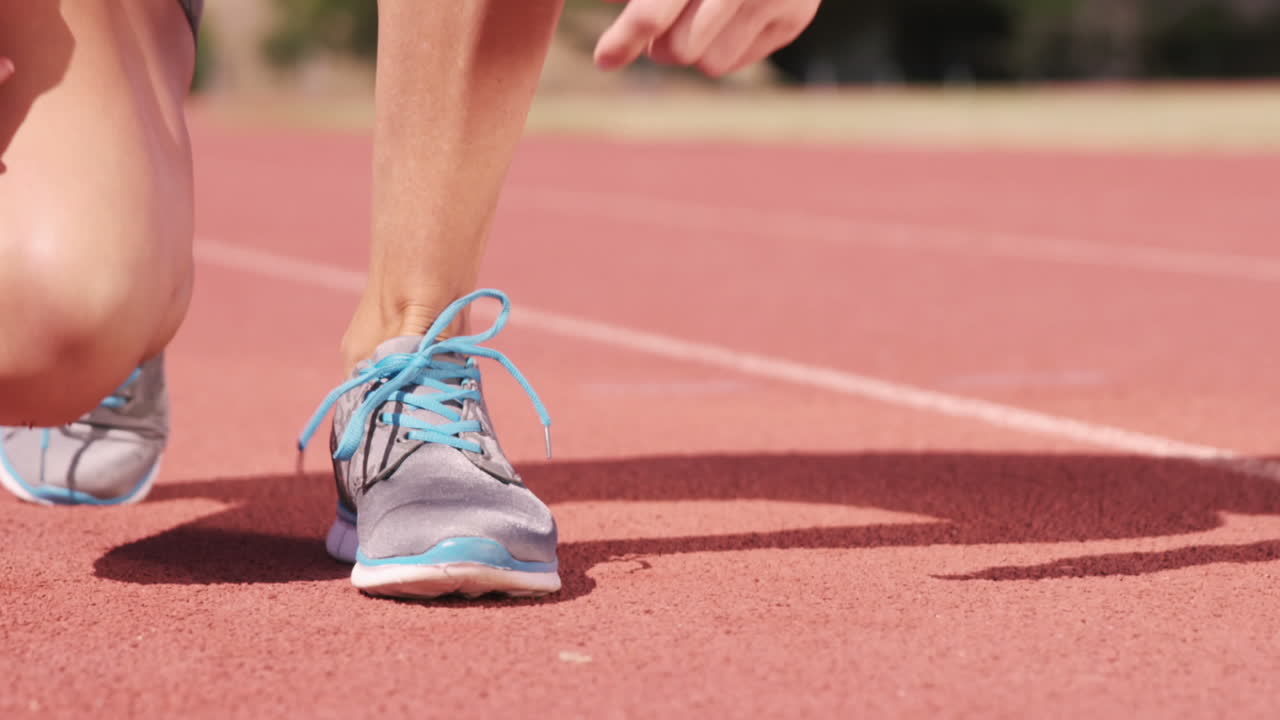 Atleta con uno smartwatch mentre si allaccia le scarpe