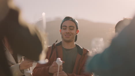 diverse group of friends celebrating rooftop party drinking alcohol young man pouring champagne enjoying reunion celebration at sunset