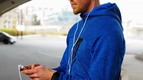 young man with headphones listening to music on mobile phone, 4k 4k