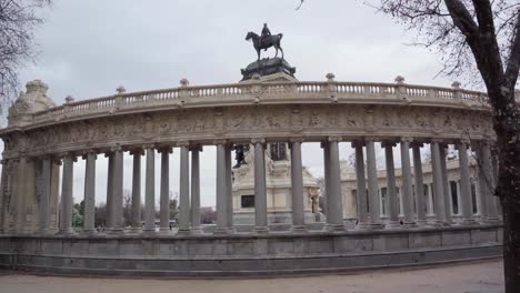 People-Walking-At-Parque-Del-Buen-Retiro-With-Alfonso-Xii-Monument-In-Madrid,-Spain