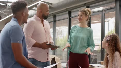 happy diverse business colleagues with tablet in discussion in casual office, in slow motion