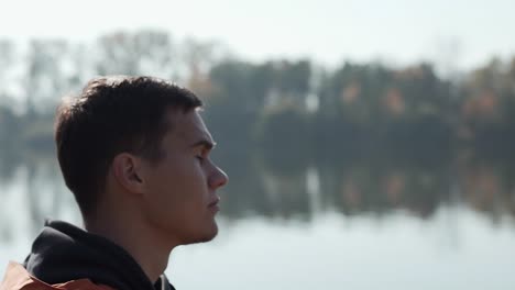 young man traveler looking the nature and breathing fresh air at the lake view