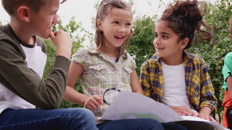 group of children on outdoor activity camping trip looking at map together