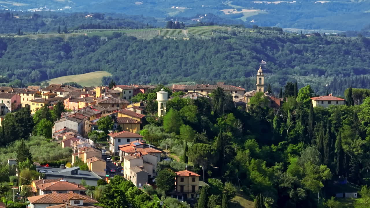 Telephoto drone shot circling the Marcialla town, sunny day in Tuscany, Italy