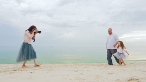 Family-Photo-Shoot-Mom-Takes-Pictures-Dad-And-Daughter-On-The-Beach
