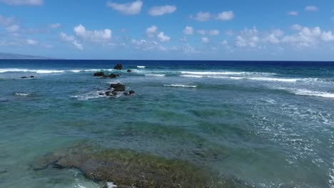 flying low along the coast of maui, hawaii on a sunny day, dolly forward