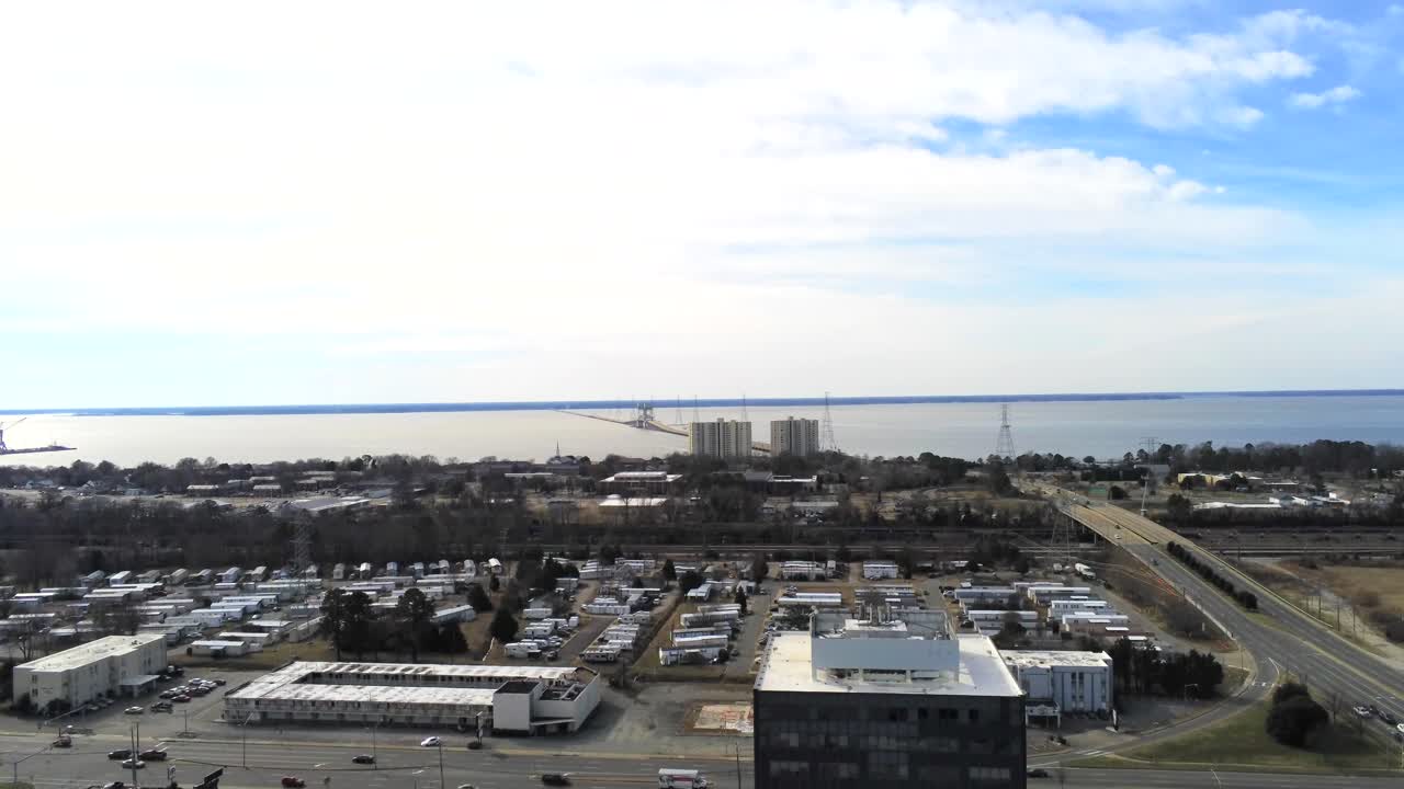 뉴포트 뉴스 버지니아의 수은 블루드와 제퍼슨 애비의 교차로, 교통, 제임스 강 다리 및 앞면의 높은 건물을 보여줍니다.