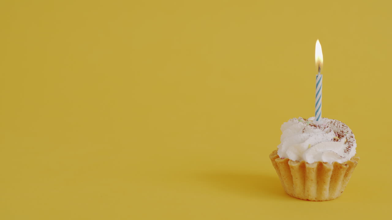 Birthday Cupcake with Candle on Yellow Background