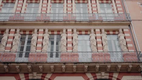 ornate balcony with statues and intricate railings on a striped building