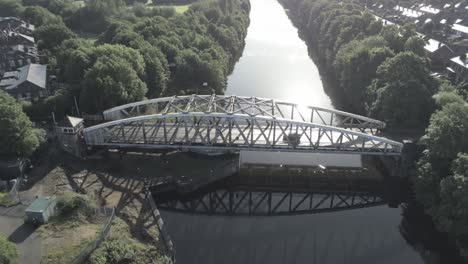 aerial rising tilt down view scenic old vintage steel archway traffic footbridge over manchester ship canal crossing