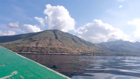 approaching a secluded remote tropical island in a local fishing boat on a beautiful calm day, atauro island, timor leste, southeast asia