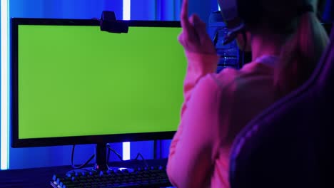 woman gamer playing games with neon lights background. green screen back ground into desktop monitor.