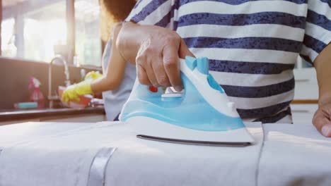 mujer mayor planchando ropa en la cocina 4k 4k