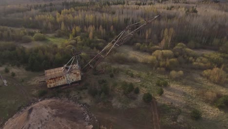 a giant walking excavator stands in an excavated quarry