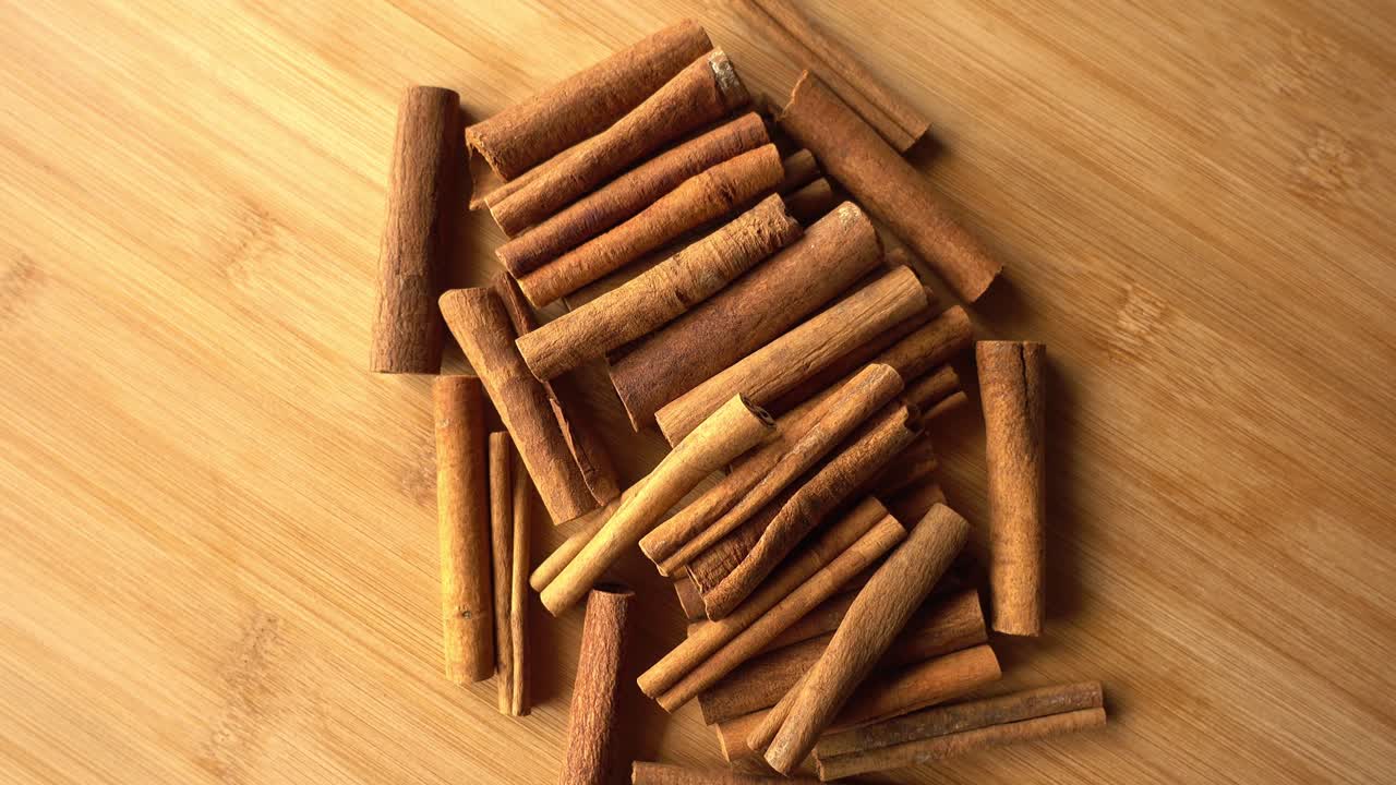 Bastoncini di cannella che ruotano come sfondo. Primo piano di cannella e spezie.