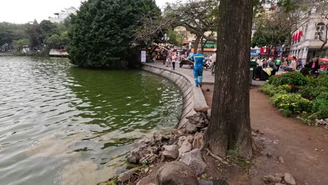 man strolling along lakeside path in hanoi