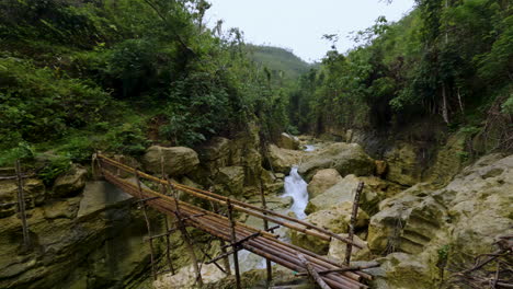 Cinematic-footage-of-a-bridge-going-over-a-river-in-the-tropical-rainforest-of-the-Philippines,-Asia,-Slow-Motion,-Slomo,-120-FPS