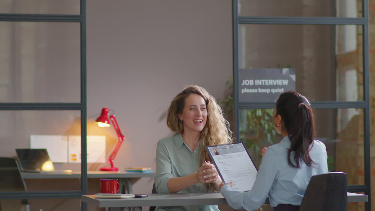 Donna che cammina in ufficio e parla con il selezionatore durante un colloquio di lavoro