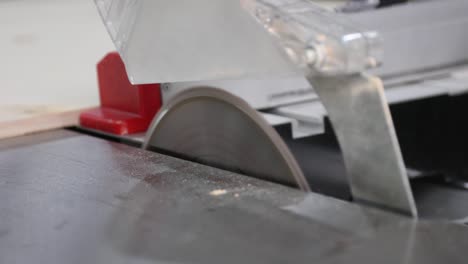 proceso de corte de madera con una sierra circular de escritorio en un taller de carpintería