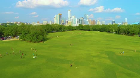 people playing sports in zikler park in austin, texas with the city skyscrapers in the background