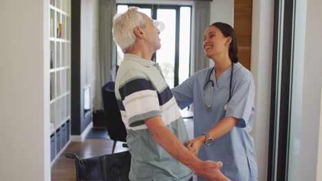 animation of happy biracial female doctor taking care of caucasian senior man