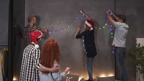 grupo de amigos más cercanos decorando la habitación con luces