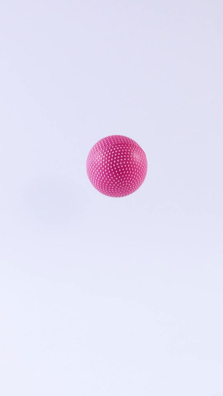 A pink ball bounces in a white space