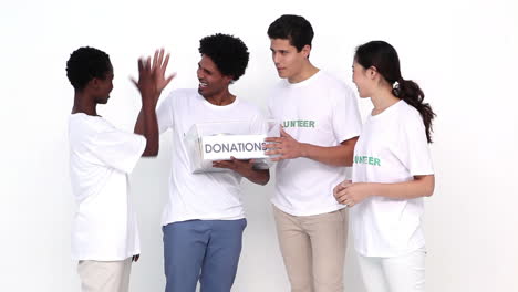 happy team of volunteers holding donation box