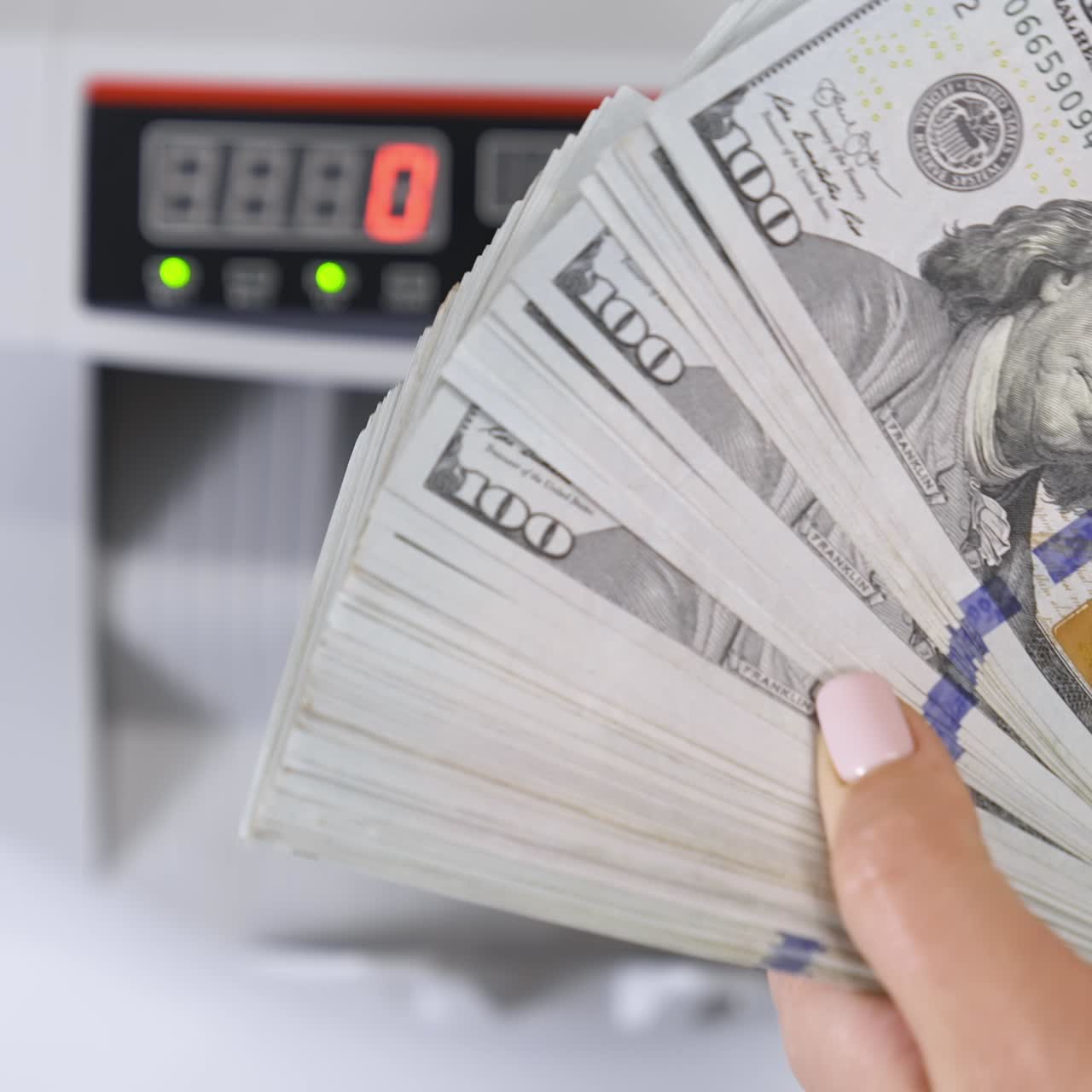 Female hands counting US Dollar bills. Money counting equipment for paper money calculation. Automatic mechanism for bank financial operations